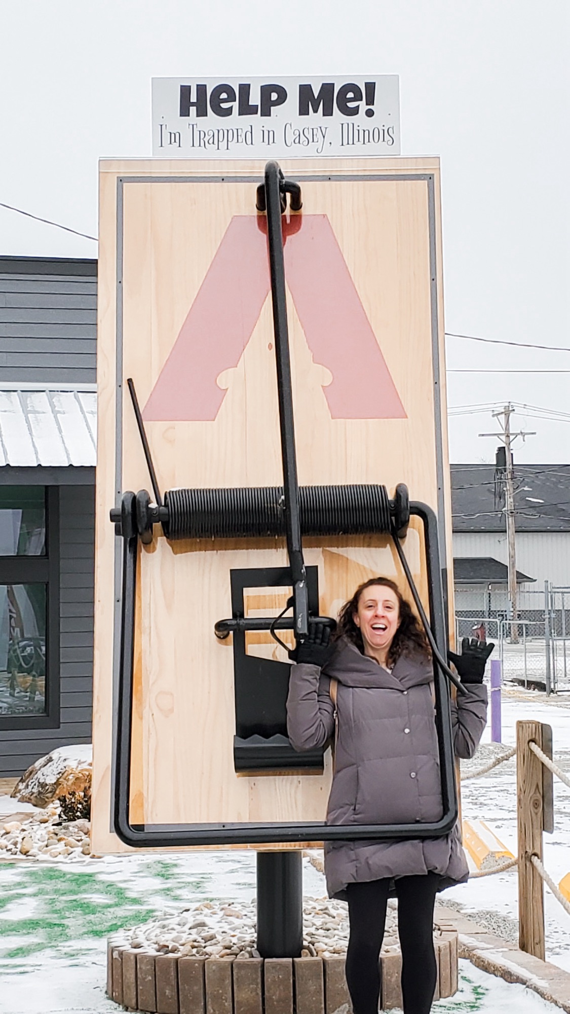 The second image is Angela caught in the Big Mousetrap. There is a sign above the mousetrap that reads, "Help Me! I'm trapped in Casey, Illinois". There is snow on the ground.