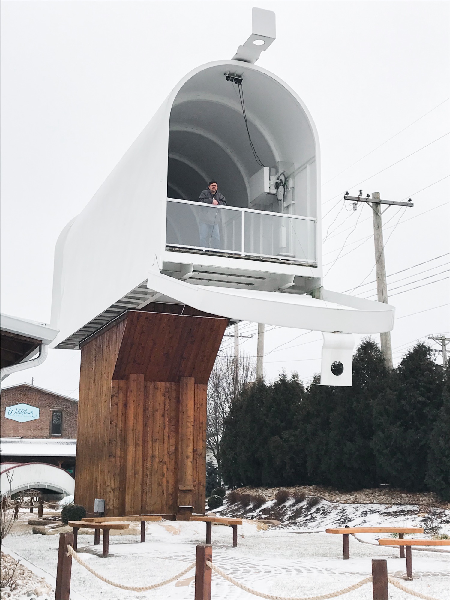 The first image is Dominic standing in the World's Largest Mailbox. There is snow on the ground.