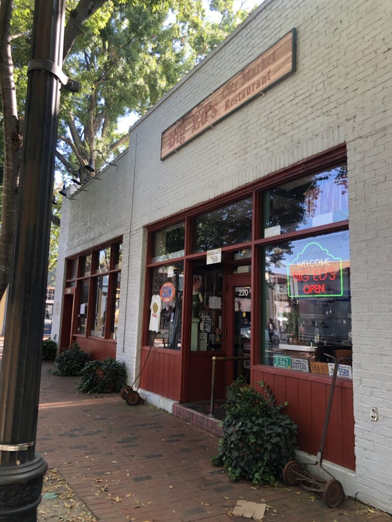 Big Ed's Restaurant in the City Market location. It's a white brick building with red trim and door.