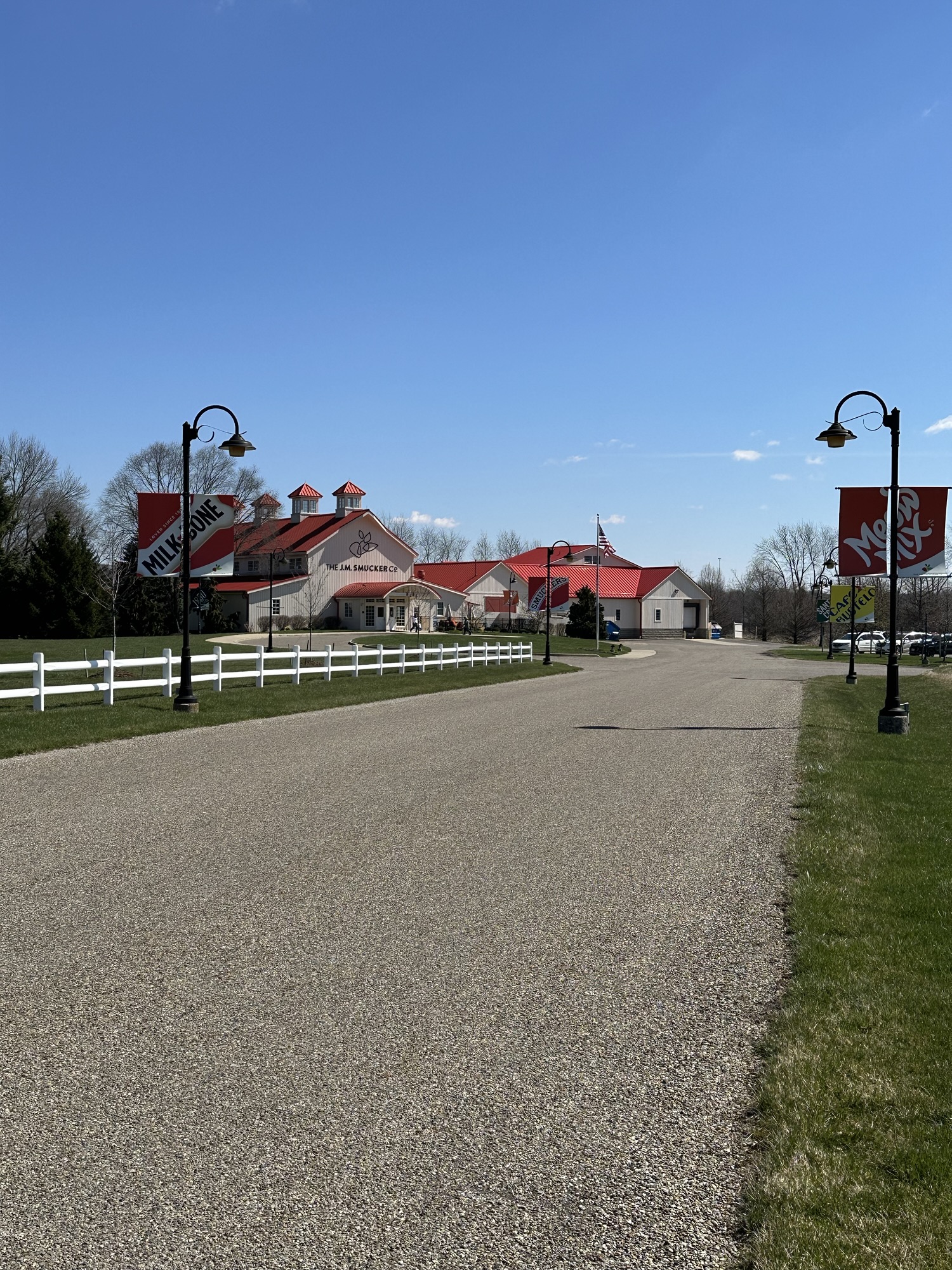 Long driveway with the Smucker's store at the end of it. There are signs on either side of the driveway that say, "Milkbone" and "Meow Mix".